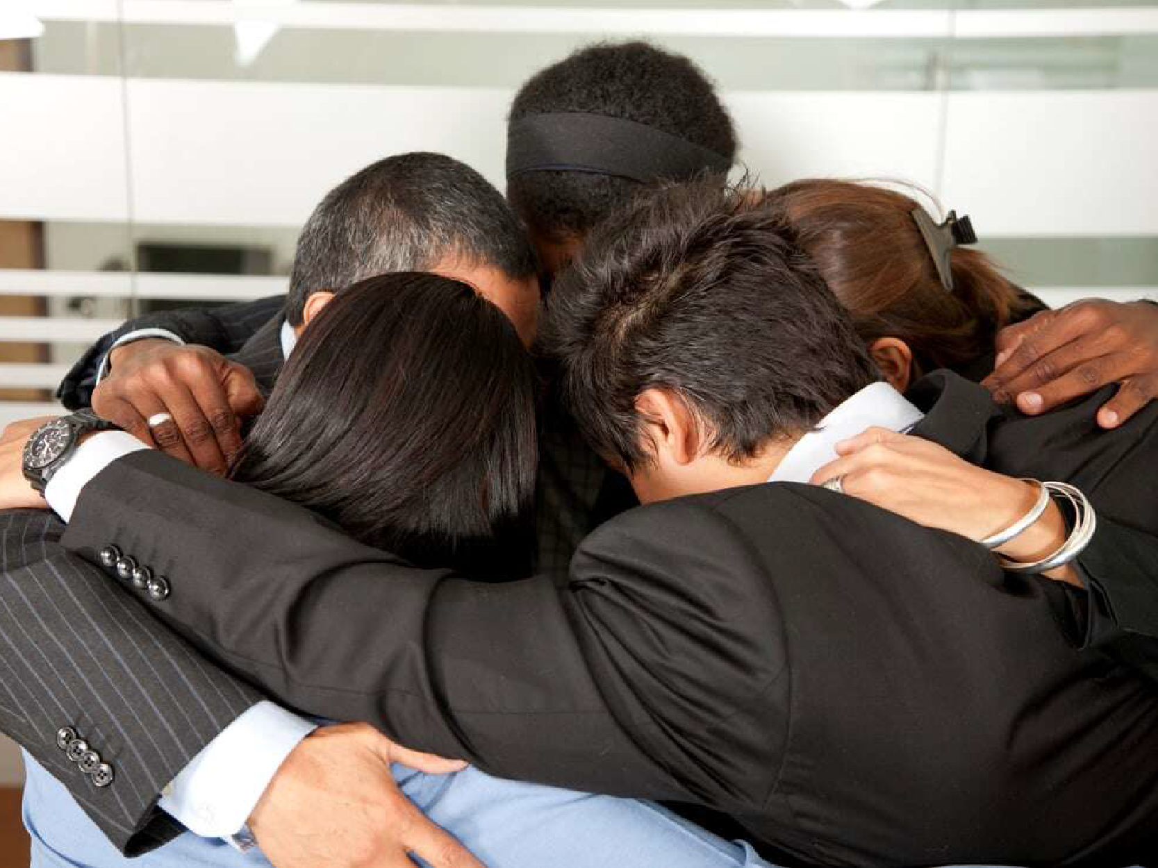 Business team hugging and planning a strategy in an office-1